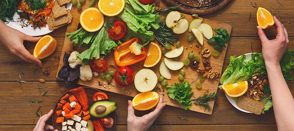 Eating healthy food, fruits and vegetables dinner table. Women at home together, top view, flat lay, crop