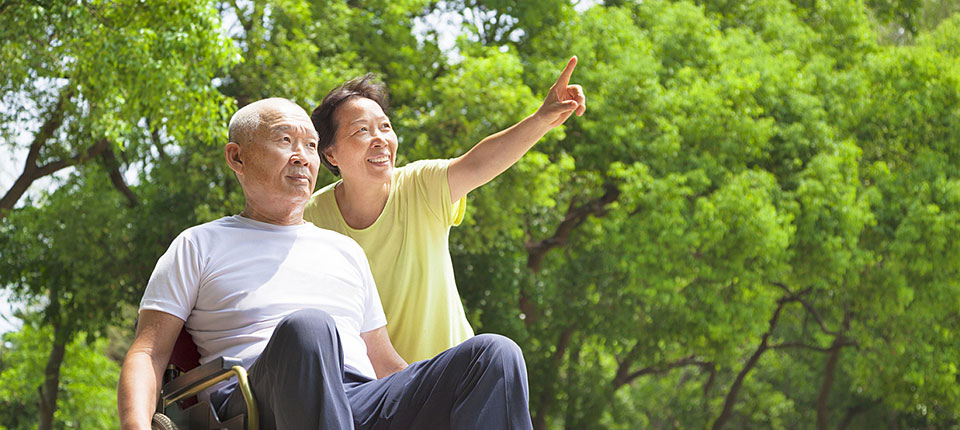 Asian senior man sitting on a wheelchair with his wife